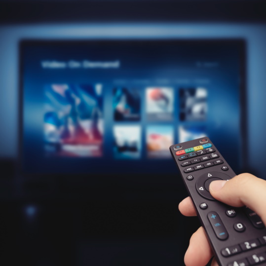 Subscriber selecting video-on-demand on a TV with a remote control